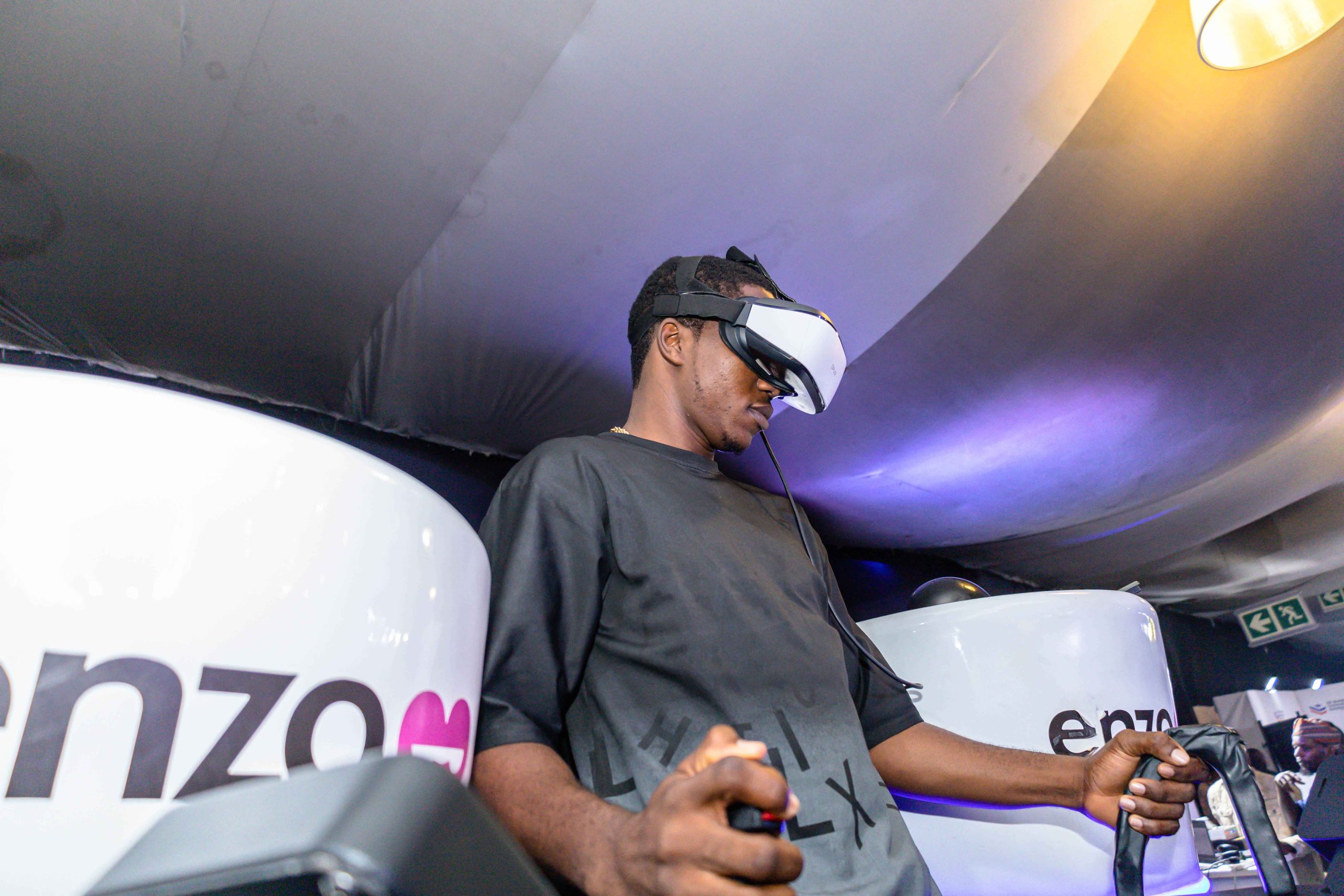 Close-up of a person using a VR controller inside Enzo Reality, with lights reflecting off their headset.